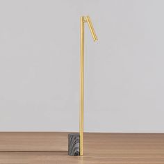 a pair of metal poles on top of a wooden table next to a white wall