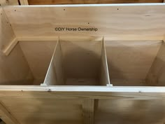 the inside of a wooden shed with two open bins on each side and an inscription that reads diy horse ownership