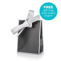 an open gift bag with a white ribbon tied around it and the words, free gift bag with every charm