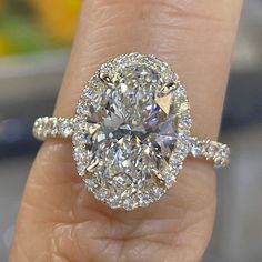 a close up of a person's hand holding a diamond ring