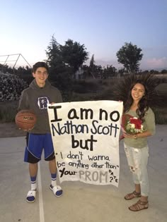 two people standing next to a sign that says i am no nathan scott, but