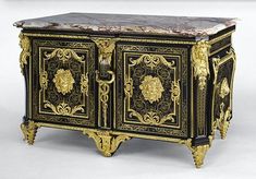 an ornate black and gold cabinet with marble top