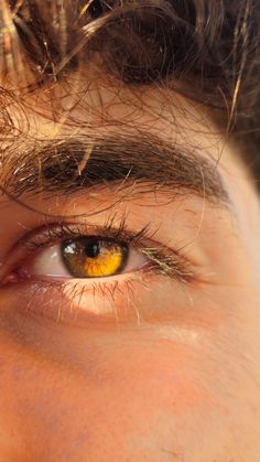 a man's eye with long hair and yellow eyeshade, close up