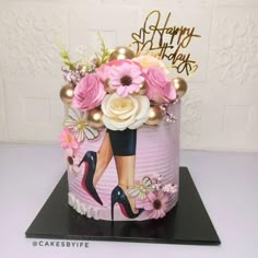 a birthday cake decorated with pink flowers and high heels