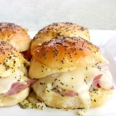 two ham and cheese sliders on a white plate with black pepper sprinkles