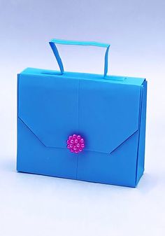 an origami blue bag with a pink flower on the front and bottom part