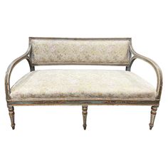 an antique style couch with white upholstered fabric