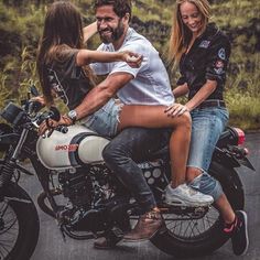 three people riding on the back of a motorcycle