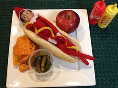 a plate topped with a hot dog, chips and an apple