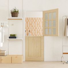 an open door in a white room with clothes on shelves