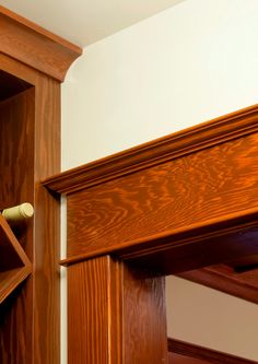 a wooden book shelf with a wine bottle in it