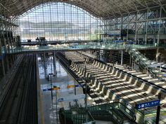 the inside of an airport terminal with lots of empty benches and luggage carts in it