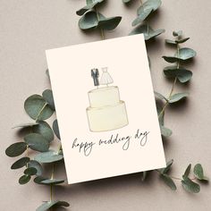 a happy wedding day card with a cake on top and greenery around it, surrounded by eucalyptus leaves