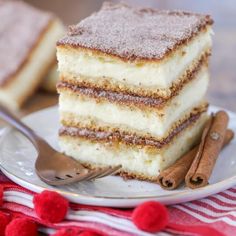 there is a piece of cake on the plate with a fork and cinnamon sticks next to it