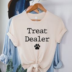 Treat Dealer Shirt, Pet Shirt, Dog Mom Shirt, Dog Shirt for Pet Owner, Dog Treat Shirt Available in all styles and colors - please message us! If you have any questions about materials, shipping times, sizes or just want to chat, please feel free to message us. Care- Machine wash in cold water, inside out, and tumble dry. Shipping: Please allow 1-5 business days for the item to be made and shipped out! Could be soon we will keep you posted! What we offer: - High Quality Soft T-shirts - Safe Paym Dog Birthday Shirts, Shirts For Dog Lovers, Pet Shirts For People, Dog Merchandise Ideas, Dog Mom Merch, Dog Mom Apparel, Dog Tshirt Ideas, Funny Dog Sayings, T Shirt Ideas