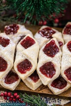 several pastries are arranged on a cutting board next to a christmas tree and decorations