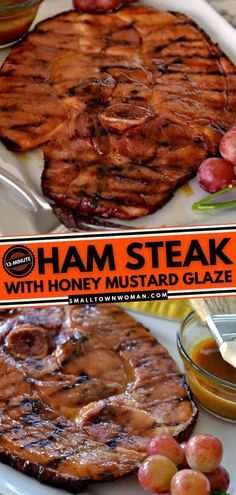 ham steak with honey mustard glaze and grapes on a white platter next to a bowl of sauce