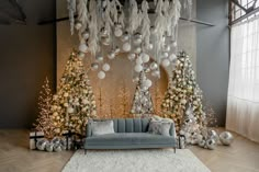 a living room decorated for christmas with silver and white decorations on the walls, couches and trees