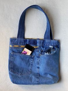 a cell phone is in the pocket of a blue jean purse on a white surface