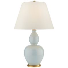 a white lamp with a gold base and a light blue shade on the top of it