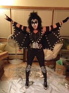 a man dressed in black and white with polka dots on his body is posing for the camera