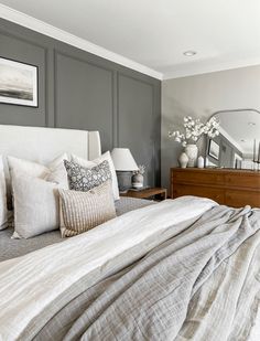 a bedroom with gray walls and white bedding