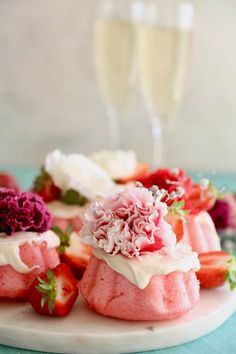 strawberry shortcakes with white frosting and fresh strawberries on the side, ready to be eaten