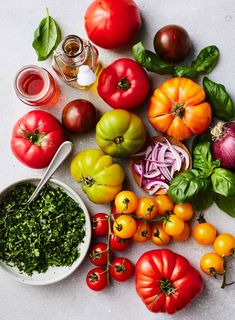 tomatoes, onions, and other vegetables are laid out on a table with pesto