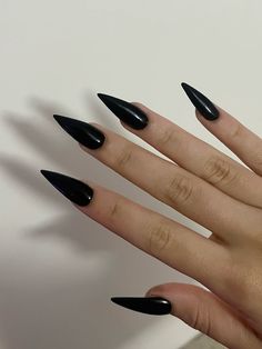 a woman's hand with black stiled nails