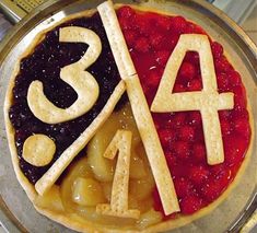 a pie with the number four on it and fruit toppings in front of it