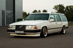 a white station wagon parked in front of a building