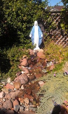 a statue of jesus in the middle of a garden