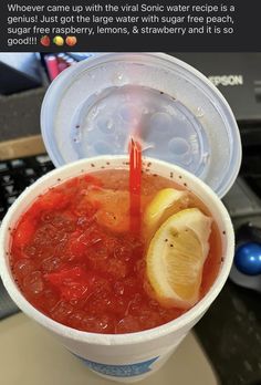 a cup filled with liquid and lemon wedges