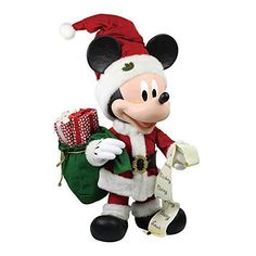 a mickey mouse christmas ornament with santa claus hat and green present bag in front of white background