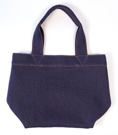 "Constructed with durable organic hemp denim, this tote bag will only get better with time! This tote features contrast topstitching and sturdy folded handles. With a unique texture and rich indigo color, this bag will soon be your favorite book, beach, or gym bag. Handmade in Denver, CO USA. Width- 18\" Height- 12\" Handle drop- 9\" Weight- 13 oz Not finding exactly what you want? Sean Ray can make it for you! Custom orders available now!" Indigo Cotton Bag For Everyday Use, Casual Bags With Contrast Stitching For Everyday, Rectangular Bags With Contrast Stitching For Everyday Use, Everyday Indigo Cotton Bag, Denim Blue Cotton Canvas Bag For Everyday Use, Eco-friendly Denim Blue Cotton Bag, Book Beach, Golden Co, Contrast Topstitching