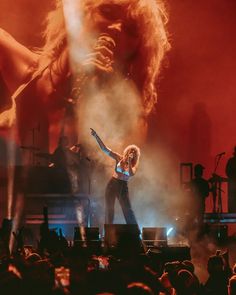 an image of a woman that is on stage with her arms out in the air