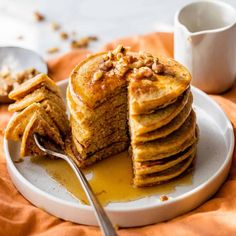 a stack of pancakes sitting on top of a white plate next to a cup of coffee