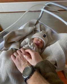 a man holding a baby wrapped in a blanket