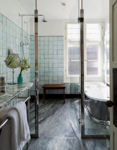 a bath room with a tub a sink and a mirror on the wall next to a window