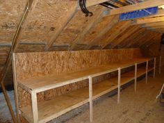 an attic with several wooden benches in the corner and one man standing next to it