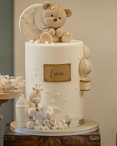 there is a white cake with a teddy bear on top and other decorations around it