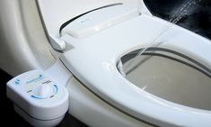 a white toilet with the lid up next to a water dispenser