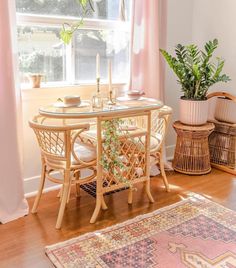 a dining room table and chairs in front of a large window with pink drapes