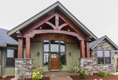 the front entrance to a home with stone and wood accents