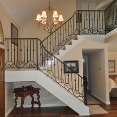 a staircase in a home with chandelier and wood flooring