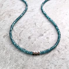 "London Blue Topaz Choker A simple string of translucent teal gemstones encircles the neck, highlighted by three 14K gold filled or sterling silver beads at the front. Simple and charming, a casual piece for everyday wear, easy to dress up. Beautiful blue/teal beads are faceted to capture the light. Versatile design, in your choice of length - also makes a nice wrap bracelet! In your choice of finish and length - extender chain also available. Please measure your neck and/or wrist before orderin Blue Gemstone Beaded Minimalist Necklace, Minimalist Blue Gemstone Beaded Necklaces, Minimalist Blue Gemstone Beaded Necklace, Minimalist Single Strand Blue Beaded Necklace, Blue Single Strand Minimalist Beaded Necklaces, Blue Minimalist Necklace With Spacer Beads, Minimalist Blue Necklaces With Spacer Beads, Blue Minimalist Necklaces With Spacer Beads, Teal Gemstones