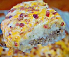 a piece of cheeseburger is being held up by a spatula with meat and cheese on it