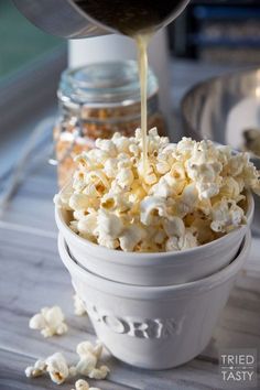 a white bowl filled with popcorn sitting on top of a table