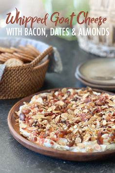 a pizza with bacon, dates and almonds sitting on top of a wooden plate