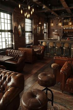 a room filled with lots of brown leather furniture and bar lights hanging from the ceiling